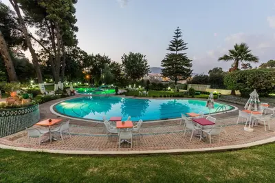 a large pool with tables and chairs in a yard at Menzeh Zalagh City Center in Fès