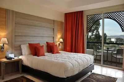 a bedroom with a large bed and a balcony at Menzeh Zalagh City Center in Fès