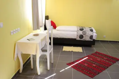 a bedroom with a bed and a table and a table and chair at Auberge Tinit in Er Rachidia