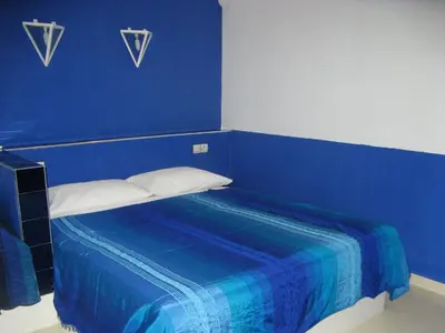a blue room with a bed with a blue wall at Auberge Tinit in Er Rachidia