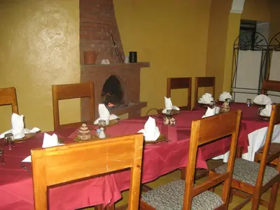 a dining room with a table and a fireplace at Auberge Tinit in Er Rachidia