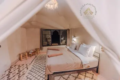 a bedroom with a bed in a tent at Ammar Luxury Camp in Merzouga