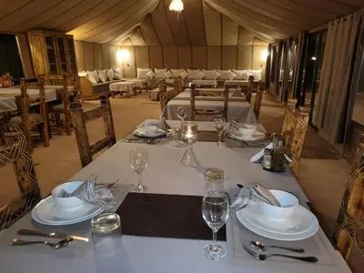 a table set up for a meal in a tent at Ammar Luxury Camp in Merzouga