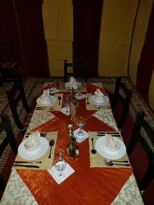 a table with plates and glasses on top at Ammar Luxury Camp in Merzouga