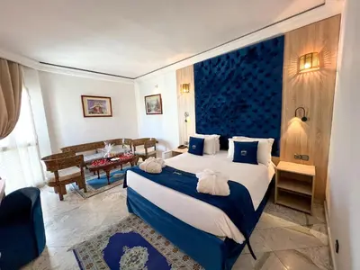 a bedroom with a large bed and a living room at Menzeh Zalagh 2Boutique Hôtel & Sky in Fès