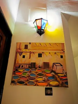 a painting on a wall with a lamp on a ceiling at Riad Farah in Fès