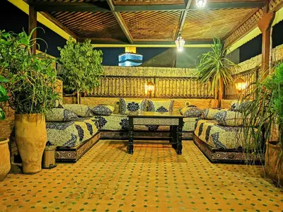 a living room with couches and a table and plants at Riad Farah in Fès