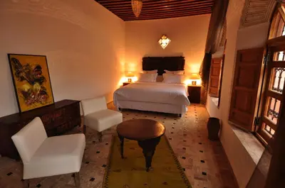 a hotel room with a bed and a table and chairs at Riad Layla in Fès