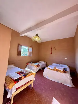 a room with three beds and a chandelier at Camping Les Palmeraies - Oasis Escape Tagounite in Tagounite