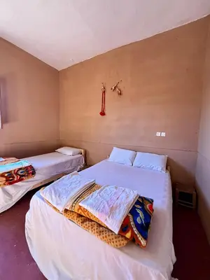 two beds in a small room with two beds sidx sidx sidx at Camping Les Palmeraies - Oasis Escape Tagounite in Tagounite