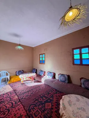 a room with two beds and a large rug at Camping Les Palmeraies - Oasis Escape Tagounite in Tagounite