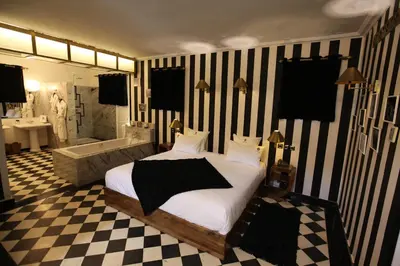 a bedroom with a bed and a bathroom with a tub at O'Atlas in El Harkat