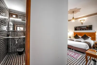 a hotel room with a bed and a bathroom at Dar D'or Fes in Fès
