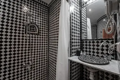 a bathroom with a black and white checkered wall at Dar D'or Fes in Fès