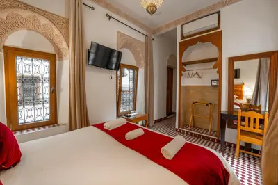 a bedroom with a large bed with a red blanket at Dar D'or Fes in Fès