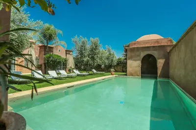 a swimming pool in a yard with lounge chairs at Villa Akhdar 18 in Ben Larbi