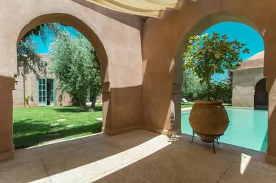 an arched entryway with a large vase with a tree in it at Villa Akhdar 18 in Ben Larbi