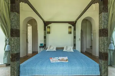 a bedroom with a blue bed with two pillows at Villa Akhdar 18 in Ben Larbi