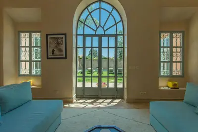 a living room with two blue couches and a large window at Villa Akhdar 18 in Ben Larbi