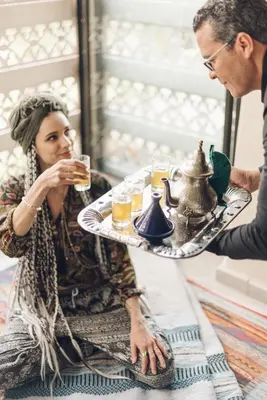 a man and a woman sitting at a table with a tray of food at Villa Akhdar 18 in Ben Larbi