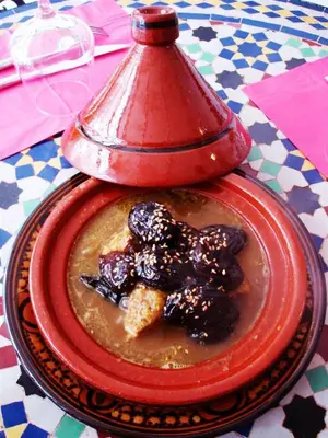 a red plate with food on a table at Al Andaloussiya Diyafa in Moulay Idriss Zerhoun