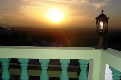 a street light on a balcony with the sunset at Al Andaloussiya Diyafa in Moulay Idriss Zerhoun