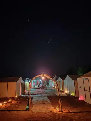 a group of tents at night with lights at Desert Camp Erg Chebbi in Merzouga