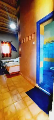 a room with a window and a bed in it at Hôtel Riad Tadarte Familier in Merzouga