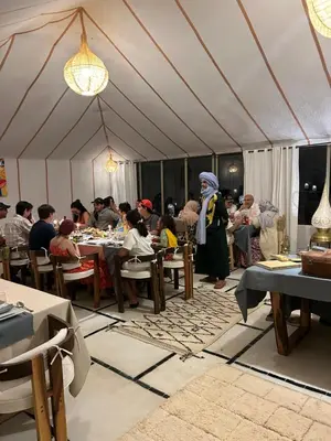 a group of people sitting at tables in a tent at Desert Luxury Camp Merzouga in Merzouga