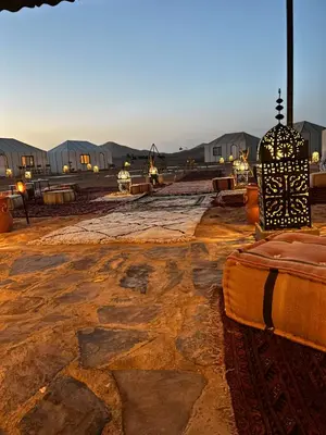 a stone courtyard with tents in the background at Desert Luxury Camp Merzouga in Merzouga