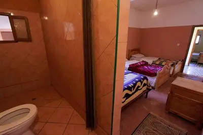 a bathroom with two beds and a toilet at kasbah Ait arbi in Aït Ougliff