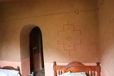 a bedroom with a wall with a cross painted on the wall at kasbah Ait arbi in Aït Ougliff