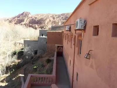 an alley between two buildings with mountains in the background at kasbah Ait arbi in Aït Ougliff