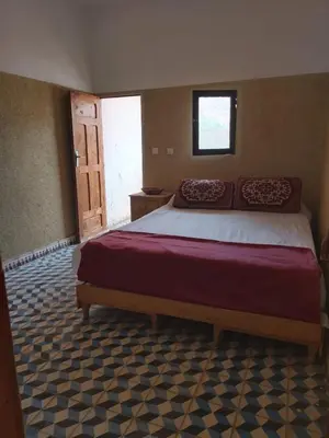 a bedroom with a large bed and a window at kasbah Ait arbi in Aït Ougliff