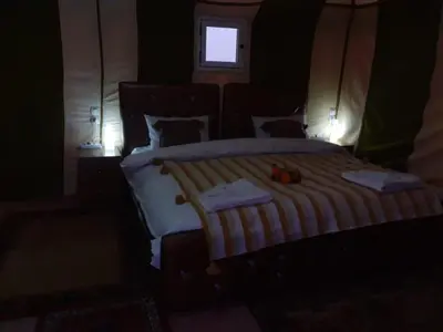a bedroom with a large bed with a window at MorokoTour Camp in Merzouga