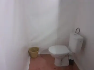 a bathroom with a white toilet in a room at MorokoTour Camp in Merzouga