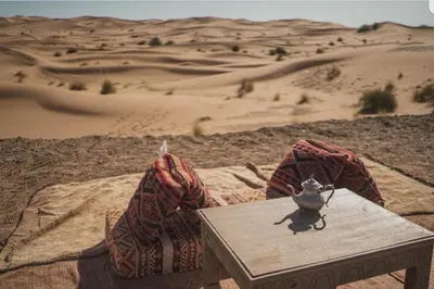 a table in the middle of the desert at MorokoTour Camp in Merzouga