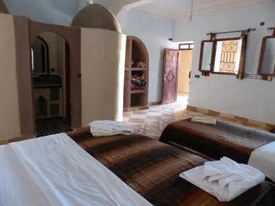 a bedroom with two beds in a room at Auberge La Source in Merzouga