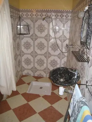 a bathroom with a sink and a tiled wall at Auberge La Source in Merzouga