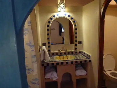 a bathroom with a sink and a mirror at Auberge La Source in Merzouga