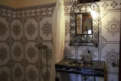 a bathroom with a sink and a mirror at Auberge La Source in Merzouga