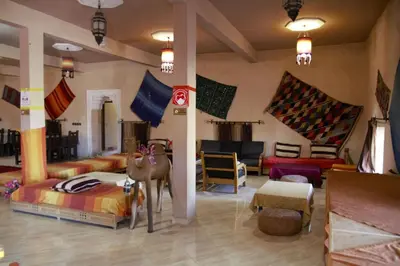 a room with beds and furniture in a room at Auberge La Source in Merzouga