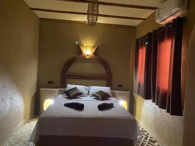 a bedroom with a bed with two hats on it at Sunny Place apartments in Merzouga