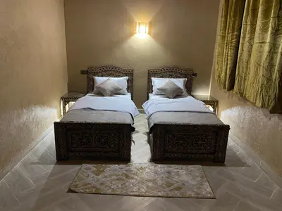 two beds sitting next to each other in a room at Sunny Place apartments in Merzouga