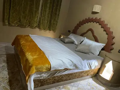 a bedroom with a large bed with a gold blanket at Sunny Place apartments in Merzouga
