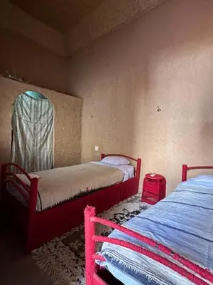 a bedroom with two beds and a mirror in it at Riad Nkob in Nkob