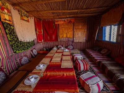 a room with a long table in a room with chairs at Mhamid Sahara Camp Activities - Le Chant du Sable in Mhamid