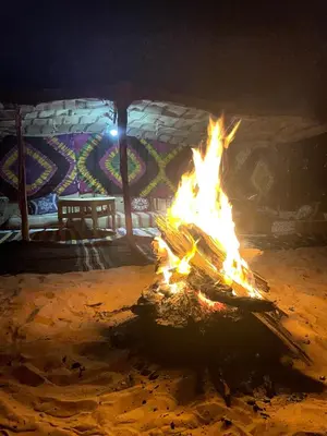 a fire pit in front of a building at night at Mhamid Sahara Camp Activities - Le Chant du Sable in Mhamid
