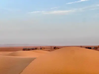 a group of sand dunes in the desert at Mhamid Sahara Camp Activities - Le Chant du Sable in Mhamid