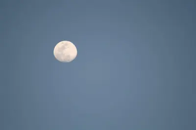 a full moon in a blue sky at Mhamid Sahara Camp Activities - Le Chant du Sable in Mhamid
